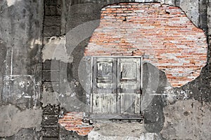 Old vintage house, background texture of a cracked and eroded wall, old bricks in the ancient cement with cracks, old wooden
