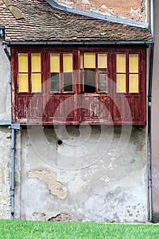 Old vintage house with wooden balcony windows and roof