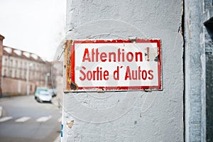 Old vintage inscription on wall building - Attention, sortie d'autos