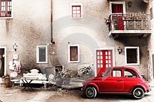 Old vintage italian scene. Small antique red car. Aging effect