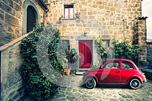 Old vintage italian scene. Small antique red car. Fiat 500