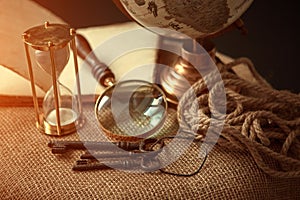 Old vintage items of the treasure hunter, traveler and discoverer - a magnifying glass, old manuscripts, a globe, keys to chests.