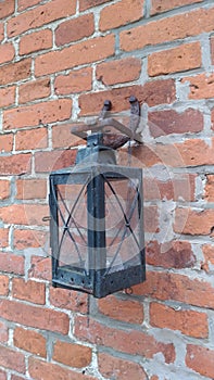 Old vintage lantern / candlestick on brick wall with horseshoe