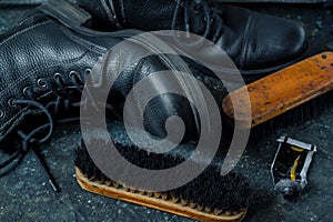 Old vintage leather boots with shoe brushes on dark background