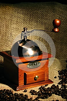 Old vintage manual coffee grinder with coffee beans