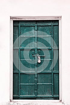 Old vintage metal door in marine green blue with a padlock