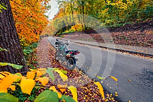 Old vintage motorcycle on the asphalt road. Calm autumn landscape.