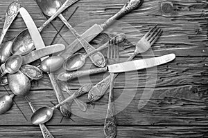 Old vintage ornamented cutlery on a wooden table