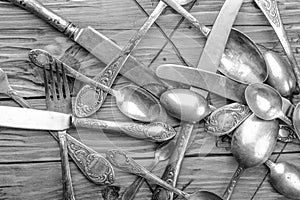 Old vintage ornamented cutlery on a wooden table