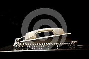 Old vintage phone with a spiral cord, black background