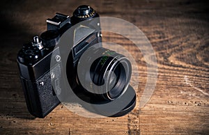 Old vintage photo camera on wooden background