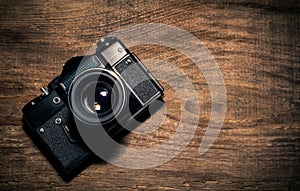 Old vintage photo camera on wooden background