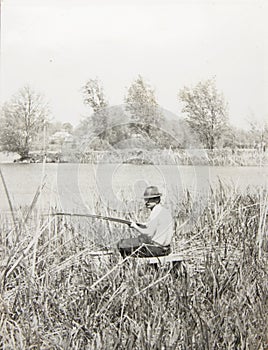 Old vintage photo man with a fishing rod