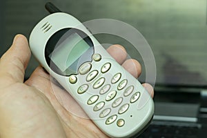 Old vintage push-button cordless phone in hand,