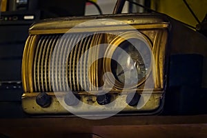 Old vintage radio receiver of the last century with rustic clock build in, on shelf