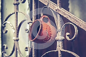 Old vintage railing with rust on the stairs in the house. Forged railing steps in the house on which the cup is hanging