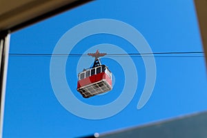 Old vintage red cable car cabin in the bright blue sky