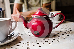 old vintage red teapot on a bohemian coffee shop
