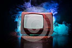 Old vintage red TV with white noise on dark toned foggy background. Retro old Television reciever no signal