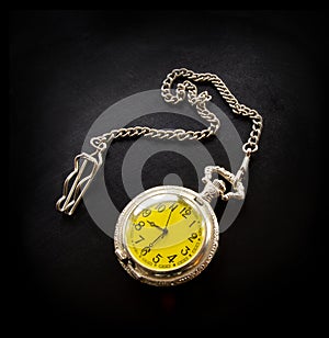 Old vintage retro antique beautiful silver pocket watch on a chain isolated on black background flat lay top view.