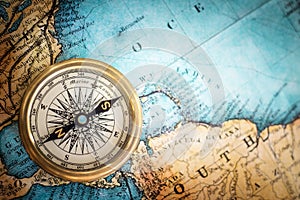Old vintage retro compass on ancient map background.