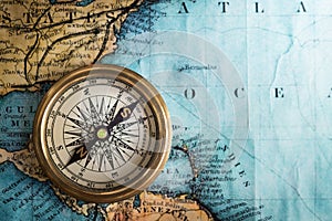 Old vintage retro compass on ancient map background. Travel geog