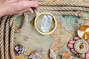 Old vintage retro compass, magnifying glass on ancient world ma