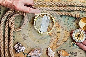 Old vintage retro compass, magnifying glass on ancient world ma