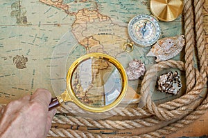 Old vintage retro compass, magnifying glass on ancient world ma