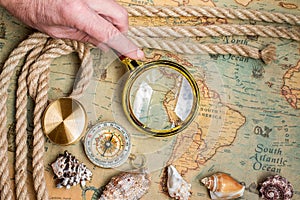 Old vintage retro compass, magnifying glass on ancient world ma