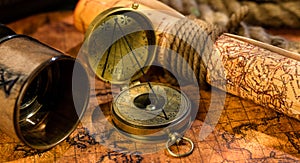 Old vintage retro compass and spyglass on ancient world map