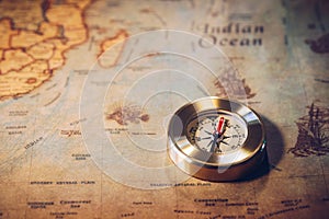 Old vintage retro golden compass on ancient map. Selective focus