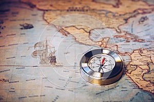 Old vintage retro golden compass on ancient map. Selective focus, shallow depth of field. Concept of world travel, sightseeing and