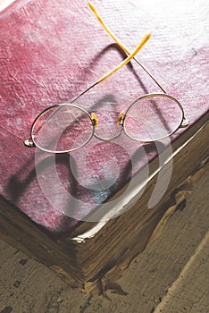 Old vintage round glasses and old book