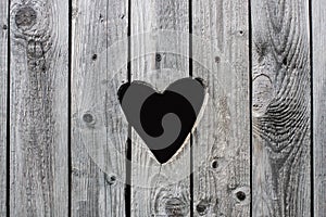 Old vintage rural toilet door with a heart shaped hole in the wooden shutters background