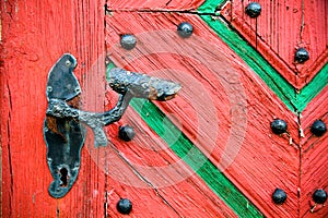 Old vintage and rusted door handle on old cracked grunge wooden door.