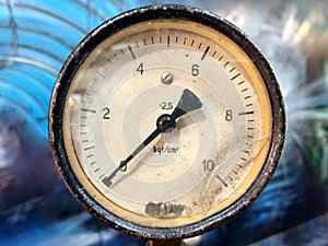 Old vintage rusty psi bar pressure measurement gauge installed on hydraulic equipment