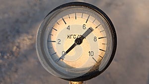 Old vintage rusty psi bar pressure measurement gauge installed on pneumatic equipment. Text in russian - kilogram-force