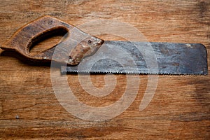 Old vintage saw of the last century extracted from the chest in the workshop of grandfather. Background for craftsmanship and