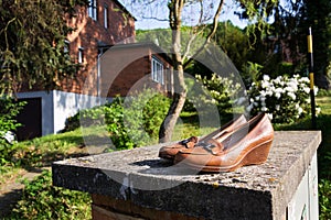 Old vintage shoes with typified red brick family Bata house in background, Zlin, Moravia, Czech Republic, sunny day
