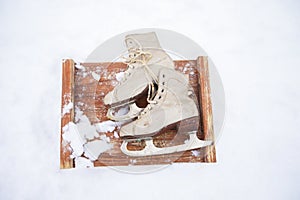 Old vintage skates on the snow.A pair of white skates