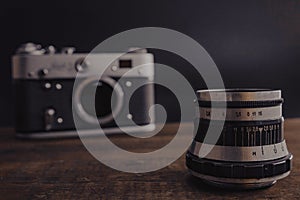 old vintage soviet camera with lens on wooden background