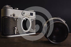 old vintage soviet camera with lens on wooden background