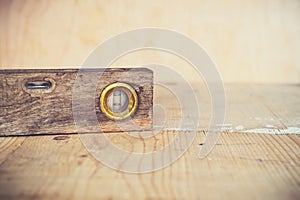 Old vintage spirit level on wooden background