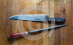 Old vintage Steak Knife and still on the wooden table, top view.