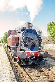 An old vintage steam train drive on the rails