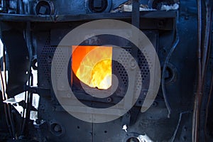 Old vintage steamtrain locomotive with fire hatch open.