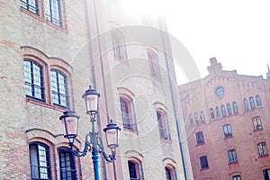 Old vintage street lamp on a background of a red brick building.