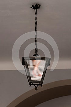 Old vintage style street lamp hanging at the house door fence. Pendant light lamp
