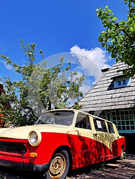 Old, vintage Trabant 601 parked in front of a house, vertical